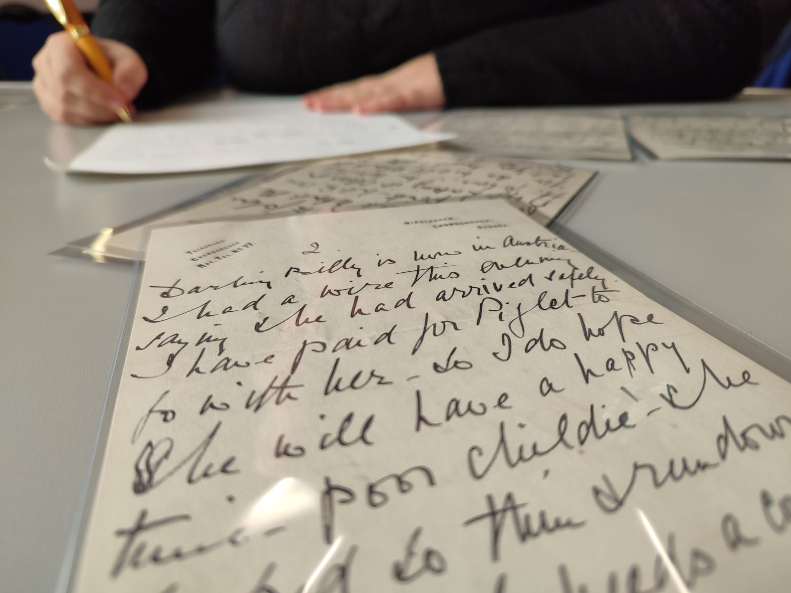 A person writing out a copy of a letter from the Conan Doyle Collection